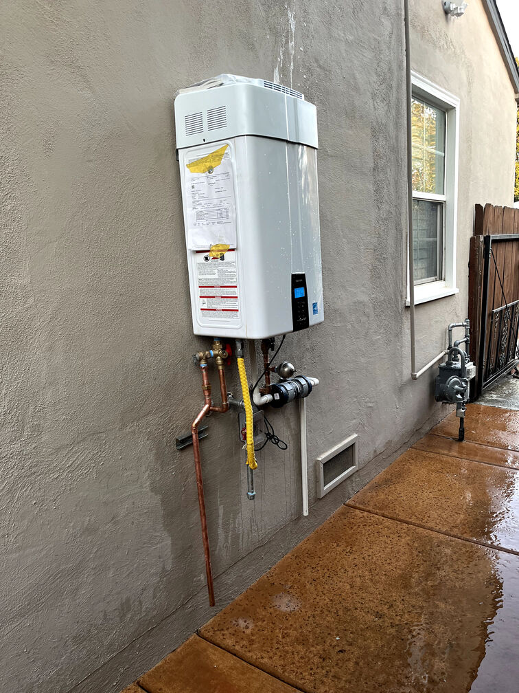 modern, wall-mounted tankless water heater installed in a compact space, emphasizing its space-saving design and suitability for homes with limited utility room square footage