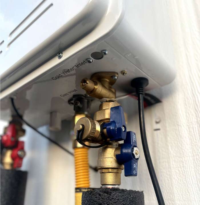 routine maintenance on a tankless water heater, including flushing the system to remove mineral buildup and inspecting components for optimal performance and longevity